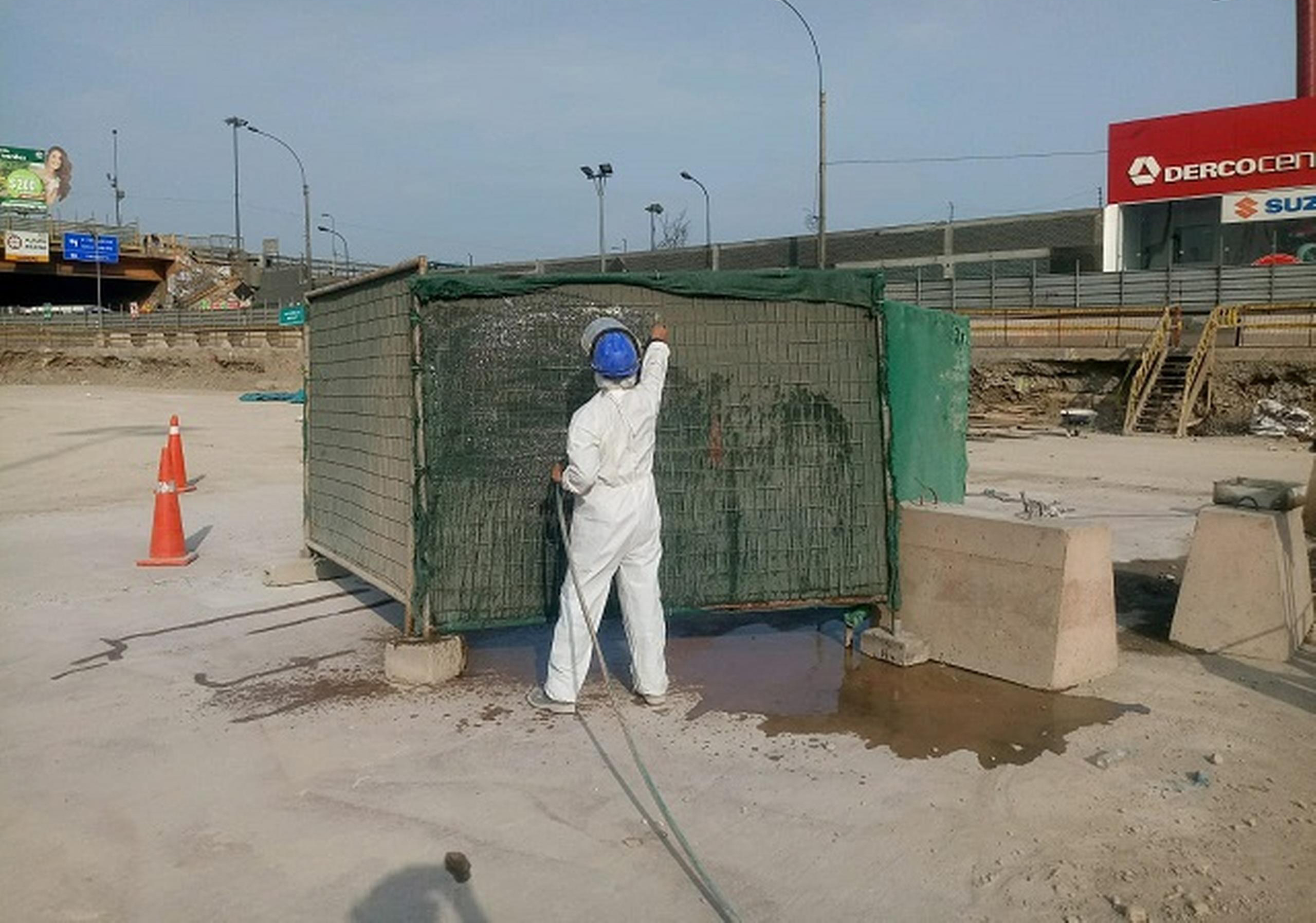 An operator dampens the raschel mesh around the concret cutting area