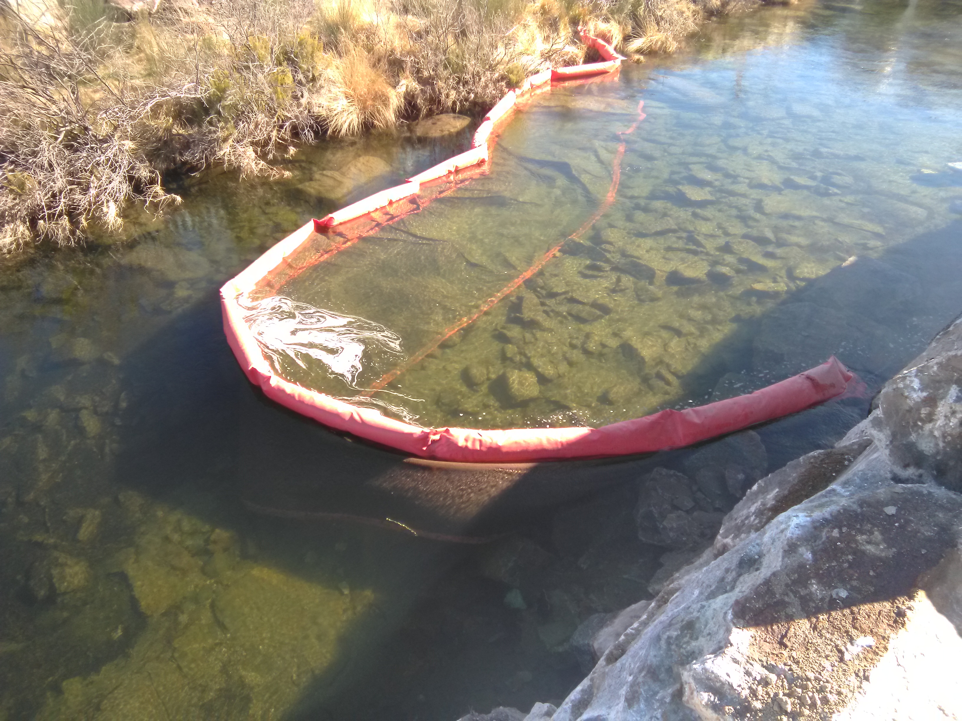 La barrera consta de una parte flotante y otra anclada al fondo que embalsa el agua turbia y la filtra