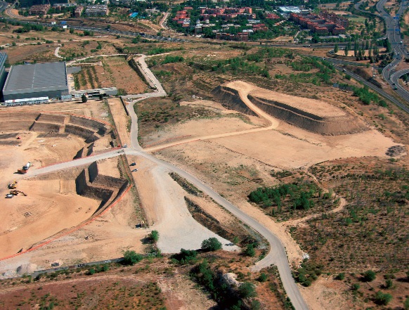 On the left, a panoramic view of the site; on the right, stockpiles of earth.